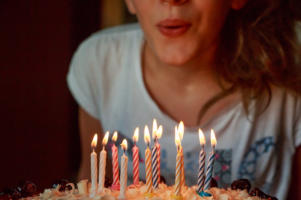 this picture shows a birthday party for adult woman blowing candles for birthday
